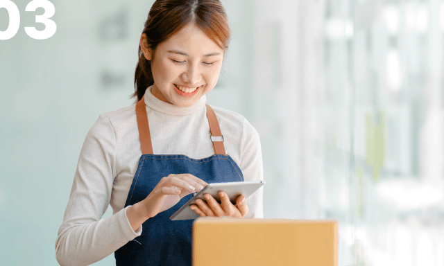 03 상품을 바라보며 웃고있는 소상공인의 모습